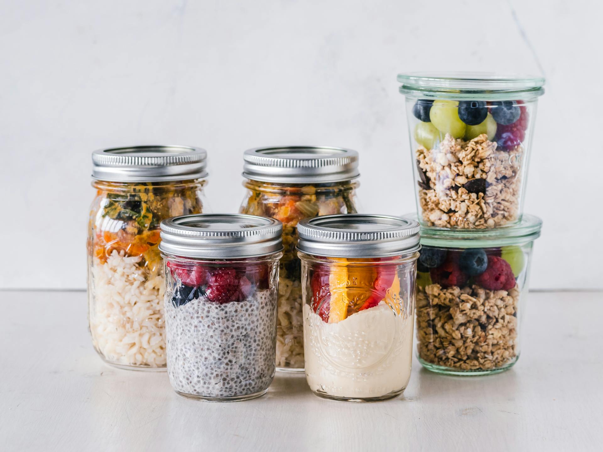 Contenants de yogurt, pouding de chia, granola et fruits.