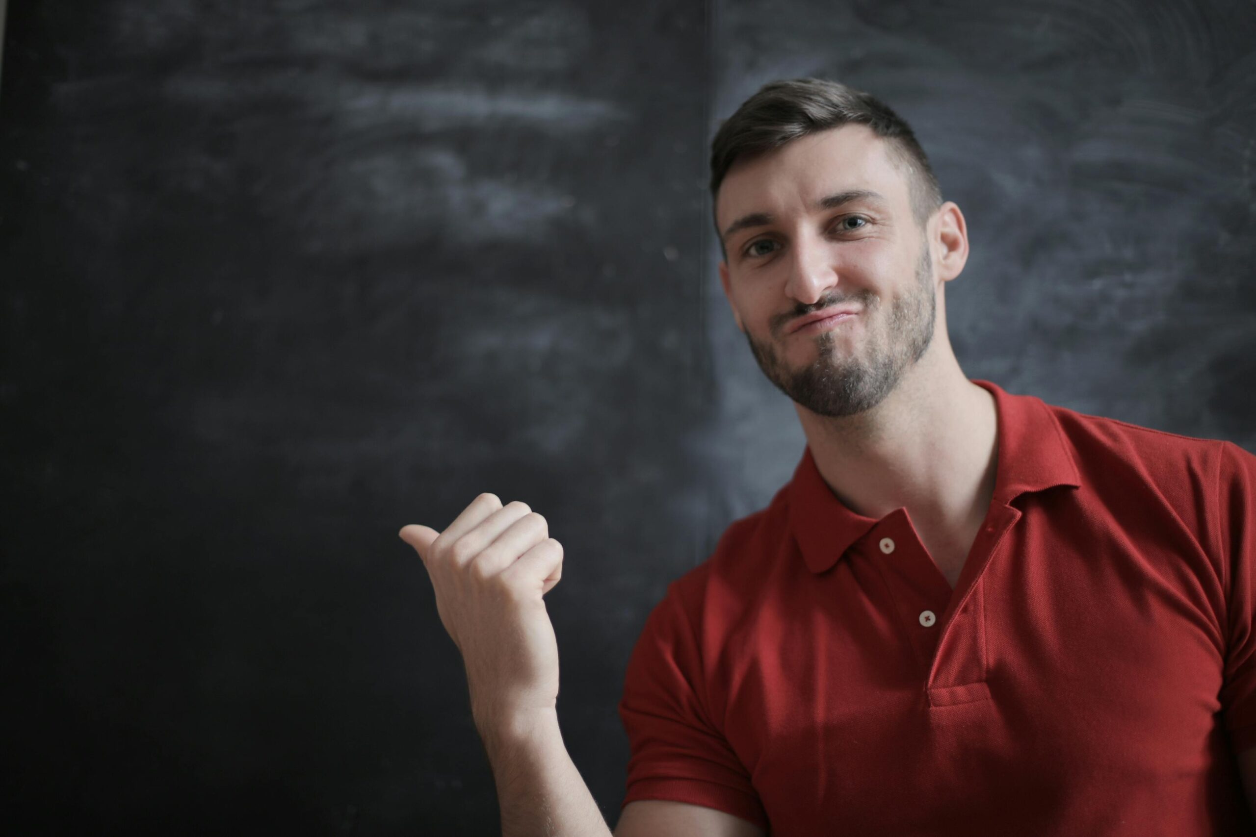 Homme qui pointe vers un tableau avec un sourire confiant