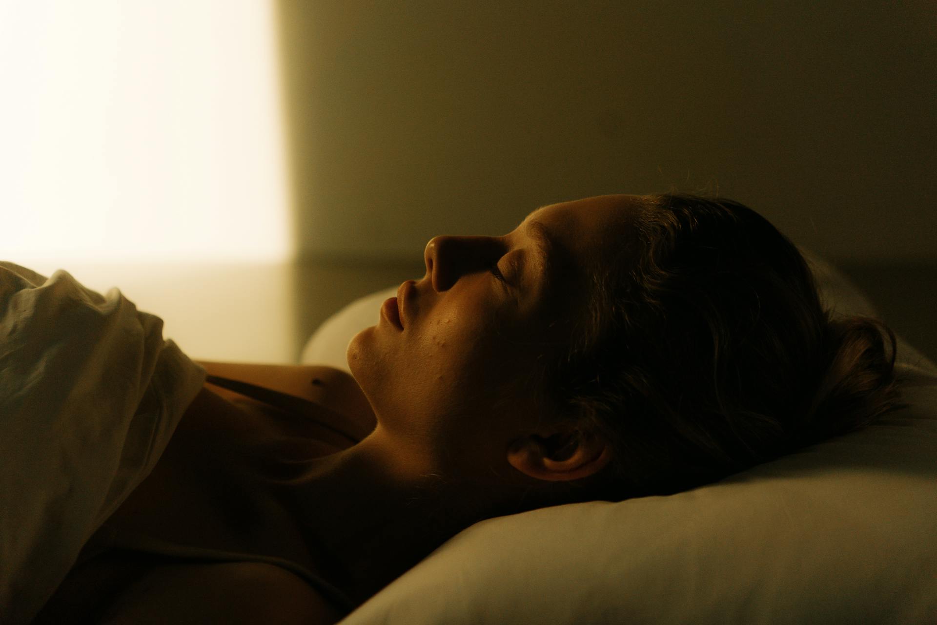 Femme qui dort dans un lit.